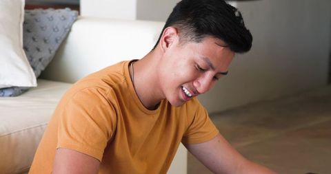 Casual Young Asian Male Relaxing Indoors with Smile