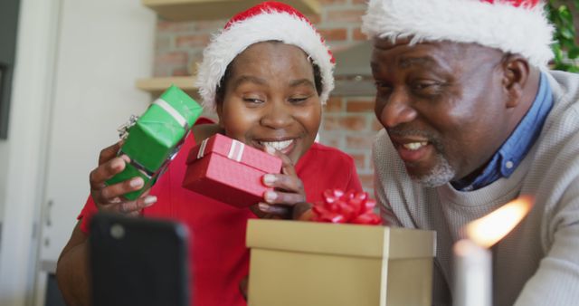 Happy Elderly Couple Wearing Santa Hats Opening Christmas Gifts - Download Free Stock Images Pikwizard.com