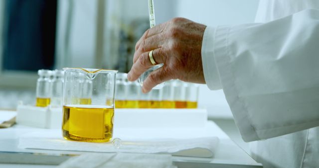 Senior Caucasian scientist measures liquid in a lab. Precision is key in the laboratory setting where experiments are conducted.