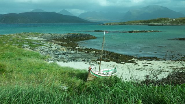 Rustic Wooden Boat on Norwegian Coast Amidst Lush Greenery and Majestic Mountains - Download Free Stock Photos Pikwizard.com
