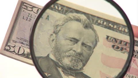 Examining Fifty Dollar Bill with Magnifying Glass