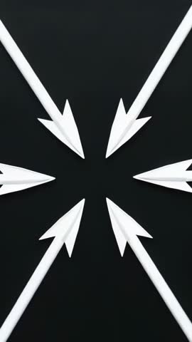 Vertical video of six white paper arrows spinning clockwise toward center on black
