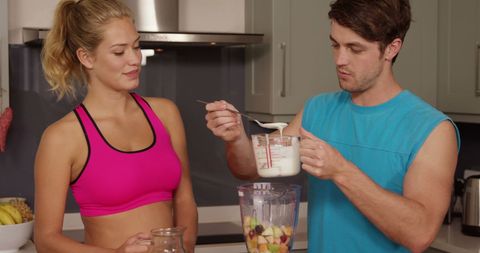 Engaged Couple Crafting Healthy Smoothies in Modern Kitchen