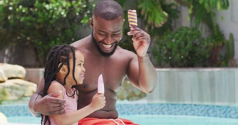 Father and Daughter Enjoying Ice Cream Together by Poolside