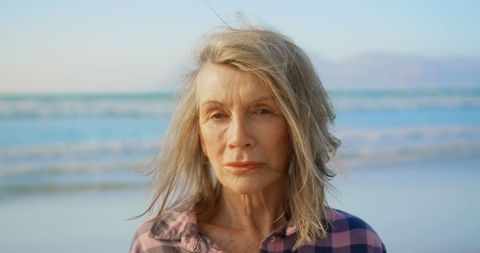 Senior Woman Relaxing on Beach at Sunset