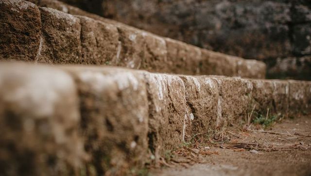 Weathered Stone Steps Showing Eroded Texture, Lichen and Moss in Outdoor Ruin