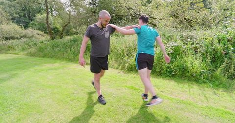 Two friends engaging in playful outdoor exercise