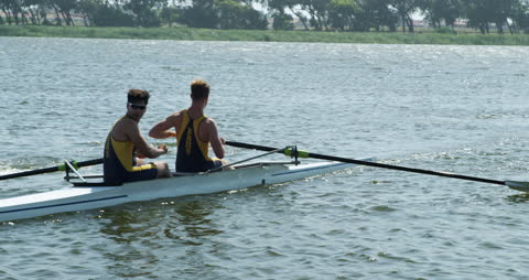 Two Male Rowers Practicing Sweeping Oars in Sunny Lake