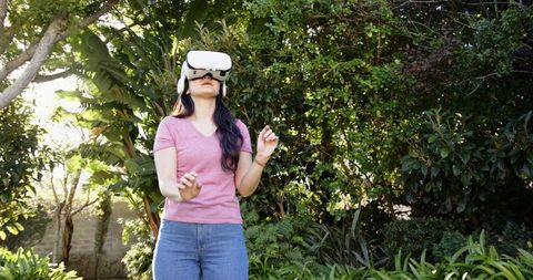 Woman Exploring Virtual Reality Outdoors in Lush Garden