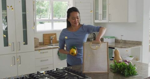 Woman in Kitchen with Reusable Bag Unpacking Fresh Vegetables