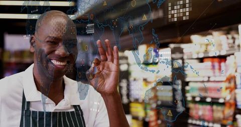 Smiling clerk in apron making ok gesture with digital world overlay
