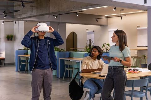 Young diverse team testing virtual reality headset in modern coworking space