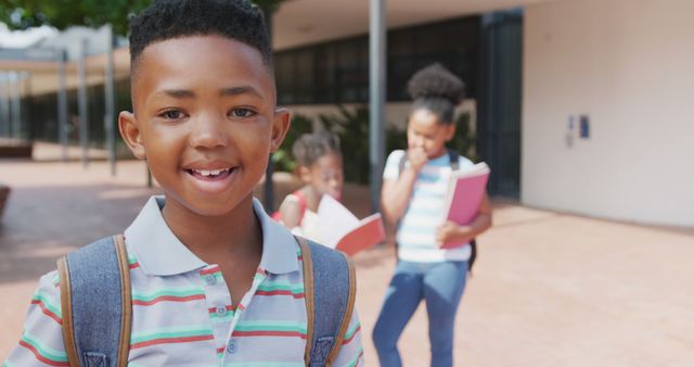 Smiling Boy in Schoolyard with Friends Holding Notebooks - Download Free Stock Images Pikwizard.com