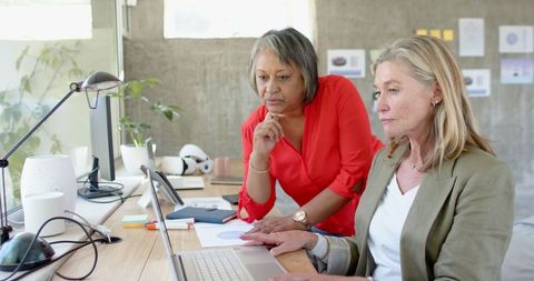 Diverse Female Colleagues Collaborating Around Office Laptop