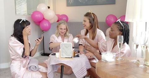 Multiracial friends celebrating hen party in pink robes
