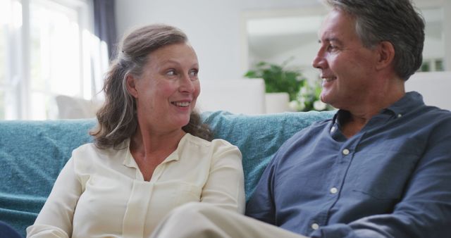 Happy senior caucasian couple sitting in living room talking and smiling. retirement lifestyle together at home.