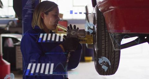 Female mechanic tightening wheel on car lift using impact wrench with ar overlay
