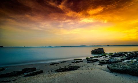 Tranquil Ocean Shore at Sunset with Vibrant Sky