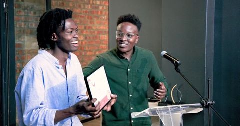 Colleagues celebrating success with award in office ceremony