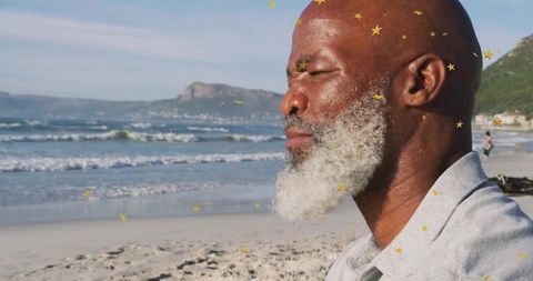 Elderly man meditating by ocean with starry aesthetic touch