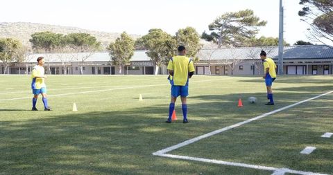 Soccer players practicing dribbling drills on bright day