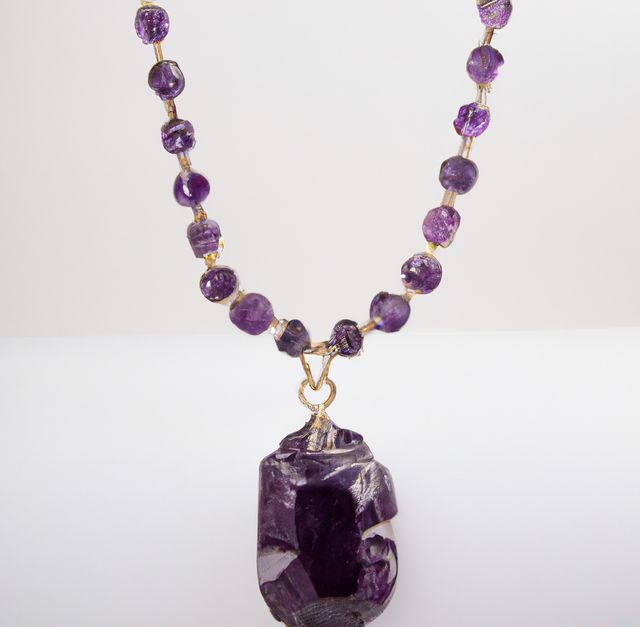 Purple amethyst beaded necklace displayed on a white background. Ideal for illustrating handmade jewelry designs, luxury accessories or fashion-related content. Can be used for e-commerce, retail websites, and marketing materials promoting elegant and unique jewelry items.