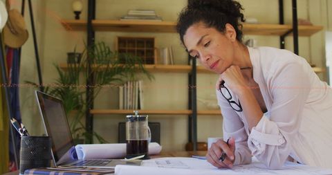Focused Woman Analyzing Financial Data at Home Desk