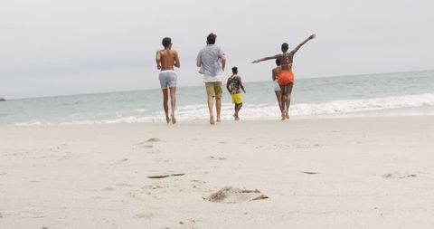 Diverse Friends Joyfully Running on Beach