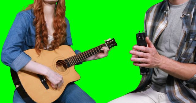 Musicians playing guitar and tambourine against green screen