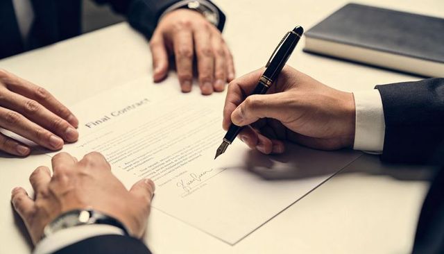 Executive Signing Final Contract with Luxury Fountain Pen at Boardroom Table