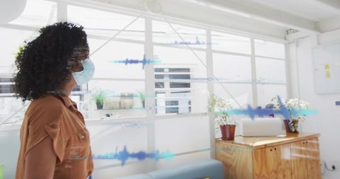 Masked colleague entering office greeting with elbow bump and audio waveform overlay