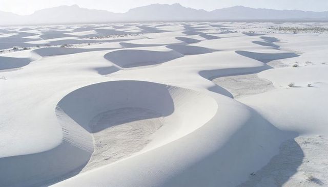 White sand dune bowls creating sculpted desert ripples and soft shadow patterns