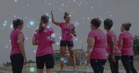 Energetic fitness instructor leading group workout outdoors