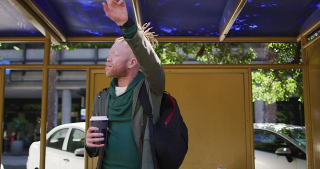 Man With Coffee Cup Waiting at Bus Stop under Blue Canopy - Download Free Stock Images Pikwizard.com