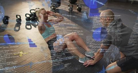 Female athlete doing crunches while trainer bracing feet in tech-driven gym with overlays