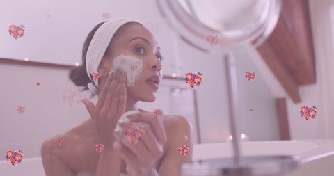 Biracial woman applying face cream during skincare routine