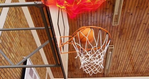Basketball stuck on hoop in indoor gym