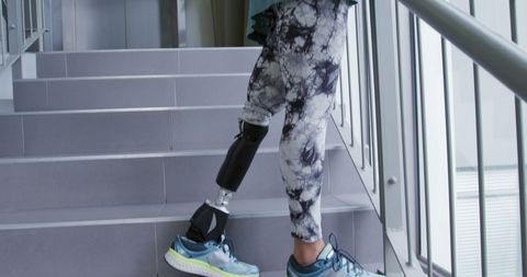 Person with prosthetic limb enhancing mobility by climbing stairs