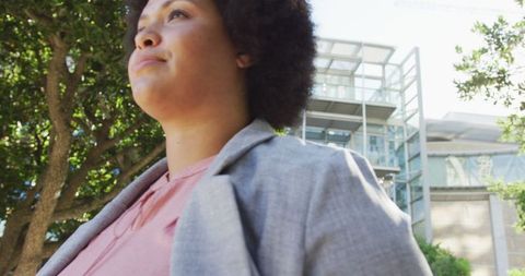 Confident Plus Size Biracial Woman Walking in Urban City Checking Smartwatch