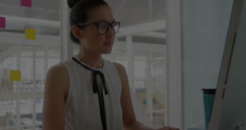 Asian Businesswoman Focusing on Task in Minimalist Office