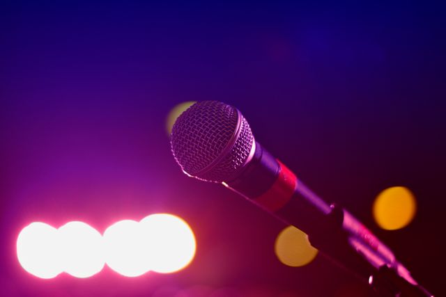 Close-up of Microphone with Colorful Stage Lights in Background - Download Free Stock Photos Pikwizard.com