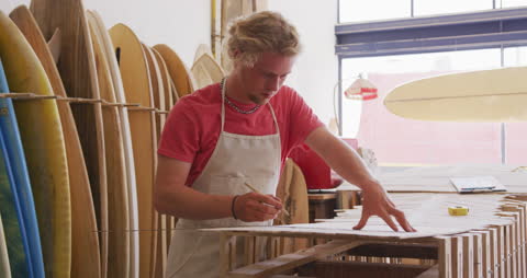 Surfboard Maker Crafting New Board in Workshop