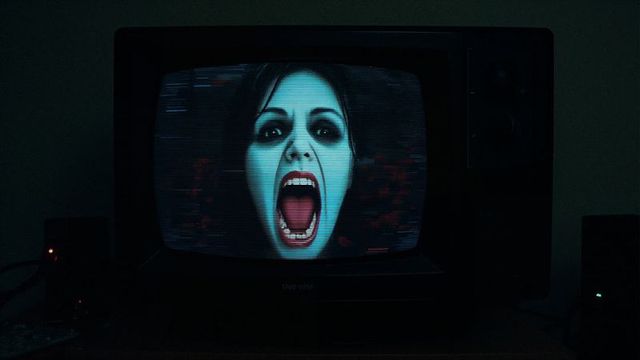 Creepy Face on Old CRT TV Screen in Dimly Lit Room
