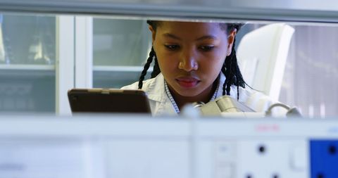 Scientist Focusing on Research Through Microscope and Tablet - Download Free Stock Images Pikwizard.com