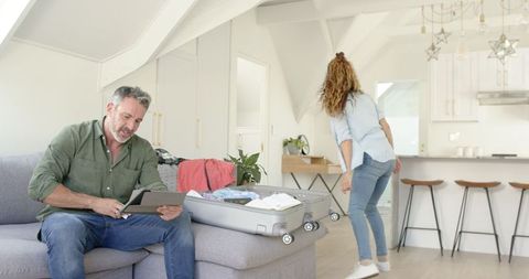 Mature Couple Packing Suitcase for Upcoming Travel Adventure