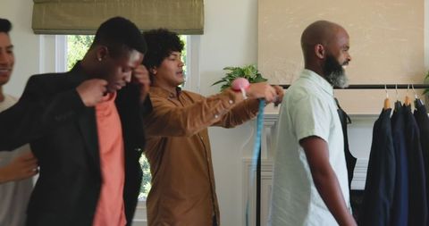 Groom preparing with friends for wedding celebration