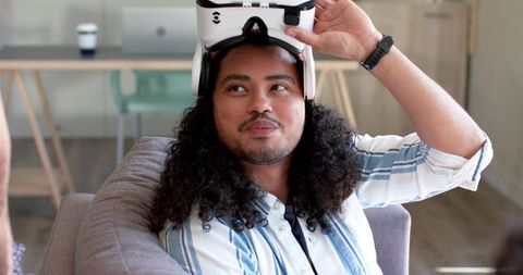 Man testing vr headset on sofa in modern lounge, wearable tech lifestyle and remote work