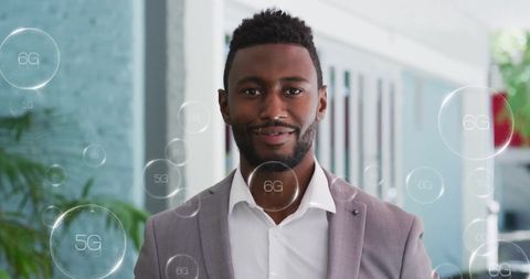 Smiling businessman in office with 5g technology concept overlay