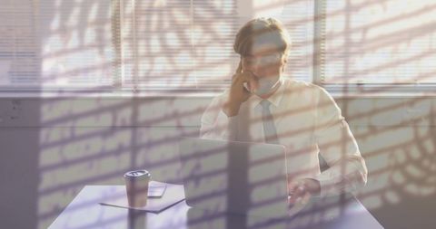 Man Working in Office Under Stress with Overlapping Plant Shadows