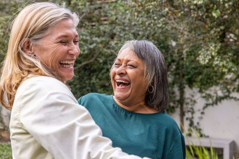 Senior Female Friends Enjoying Laughter in Garden